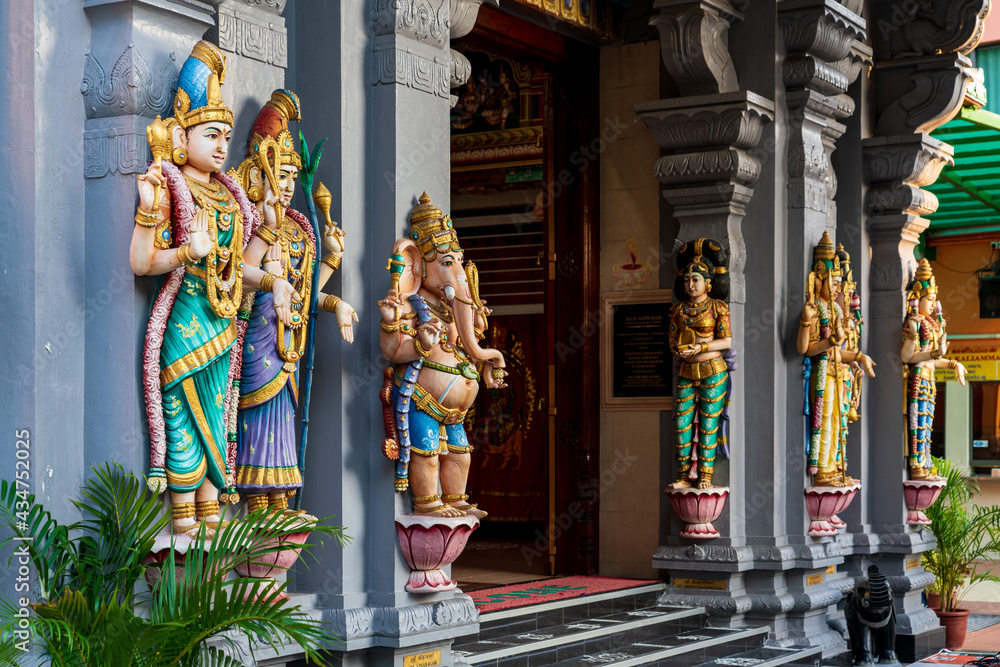 Wall mural colourful statues of hindu religious deities adorning the interior of a hindu temple in singapore.