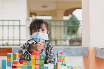 Asian girl kid playing toy. Little girl relax with playing blocks. cute girl Wear black skirt Have fun At home.