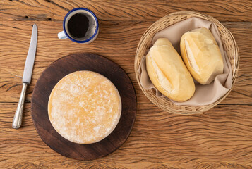 Artisanal Canastra cheese from Minas Gerais, Brazil with bread and coffee cup over wooden table