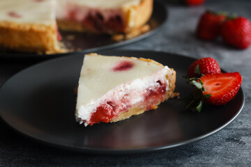 Delicious pie with strawberries and cream. Pie on the table. Pie with berries on a plate 