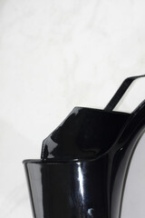 Black patent leather strips / high-heeled shoes on white background