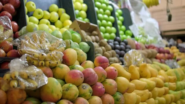 Colorful fruit stand with tangerines, apples, mangoes, bananas, and more