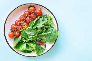 tomato cherry salad green leaves fresh mix greens spinach, arugula, lettuce ingredient on the table healthy food meal snack copy space food background rustic keto or paleo diet veggie 