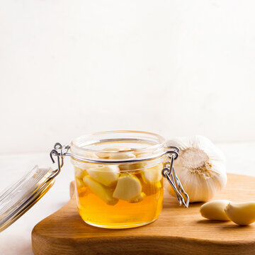 Fermented honey with garlic on a white plate. Copy space