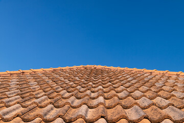 Close up of brown clay roof tiles. Red old dirty roof. Old roof tiles. Construction equipment build a house.