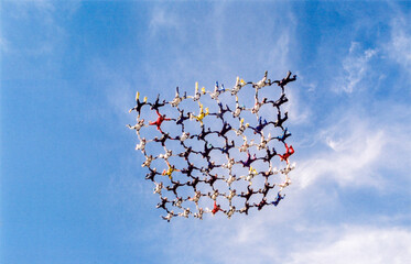 Skydiving formation with 64 skydivers, togetherness concept