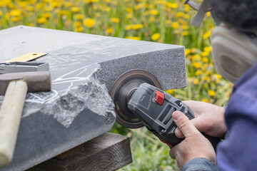 Street lighting. a masked worker processes a granite stone with a special tool. Close-up.
