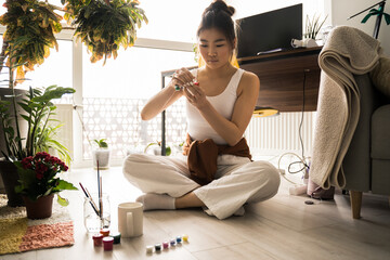 Female artist preparing to paints picture on cup with acrylic paints