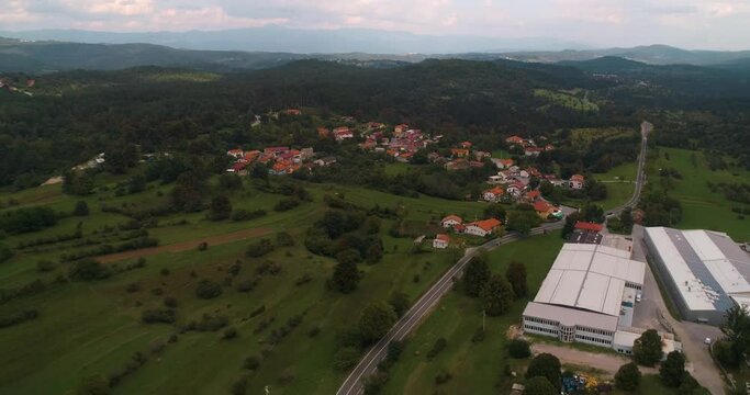 Aerial view away from a small town in cloudy, Slovenia- pull back, drone shot