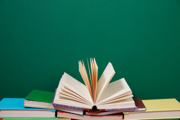 Composition with vintage old hardback books, diary, fanned pages on wooden deck table