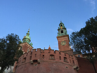 Looking up towards the Clock Tower and Sigismund Tower from the Herbowa Gate in Krakow, Poland