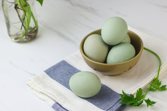 Telur bebek rebus or boiled duck eggs on ceramic bowl. White background, copy space for text. 