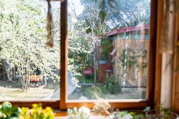 部屋の窓から眺める緑あふれる庭の風景　小屋