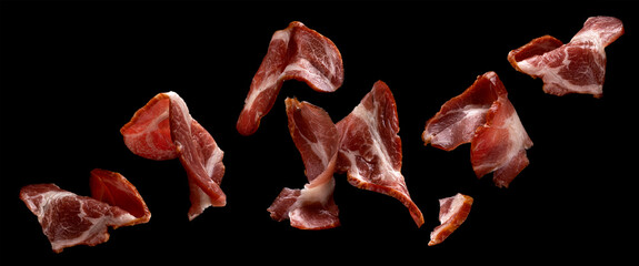 Falling sliced bacon isolated on black background