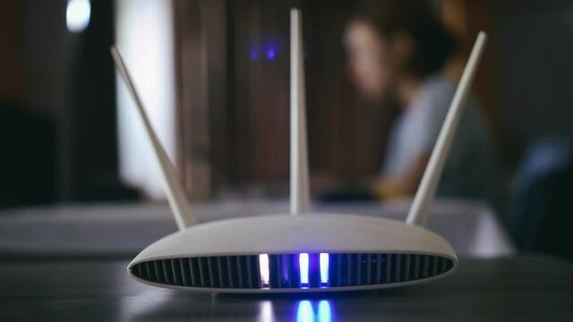 A woman is working at home using a modem router, connecting the Internet to her laptop.