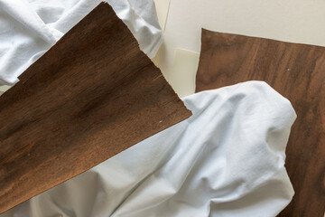 fabric, paper, dark wood veneer sheet - photographed from above with natural, ambient light