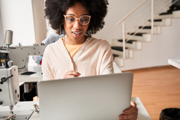 Woman advicing with her colleagues using laptop during the re sewing