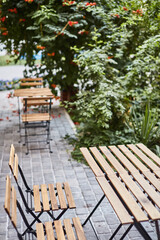 Fototapeta na wymiar table and chairs on the terrace empty street cafe with garden