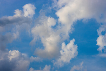 White clouds moving under the sunny blue sky