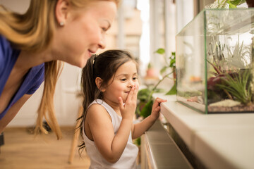 Girl laughing out loud while peeking into the terrarium