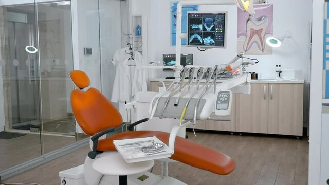 Interior of stomatology orthodontic hospital office with nobody in it ready for dental surgery equipped with modern dentistry tooth instruments. Orthodontist room with teeth xray images on display