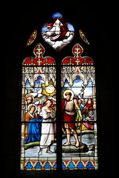 Stained glass window in St Germain church, Rugles, France. St John the Baptist baptizing Jesus.