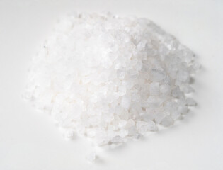 pile of coarse sea salt closeup on white