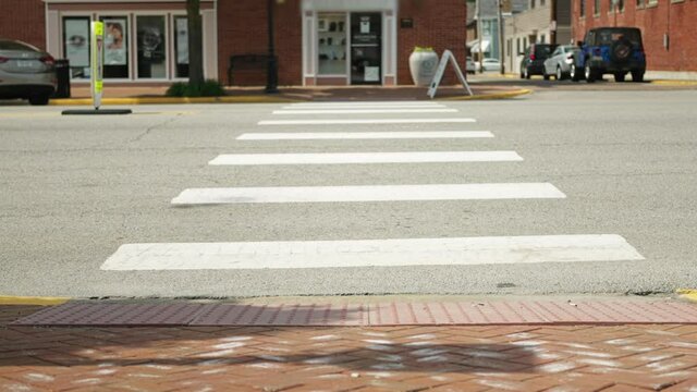 A low angle slow motion view of a crosswalk along the main street of a small Pennsylvania town. Pittsburgh suburbs.  	