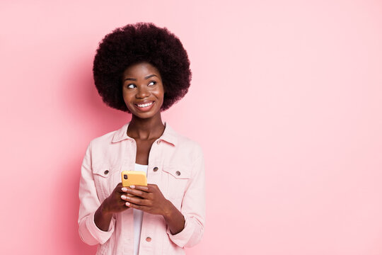 Portrait of pretty cheerful girl influenzer using gadget creating post copy space isolated over pink pastel color background