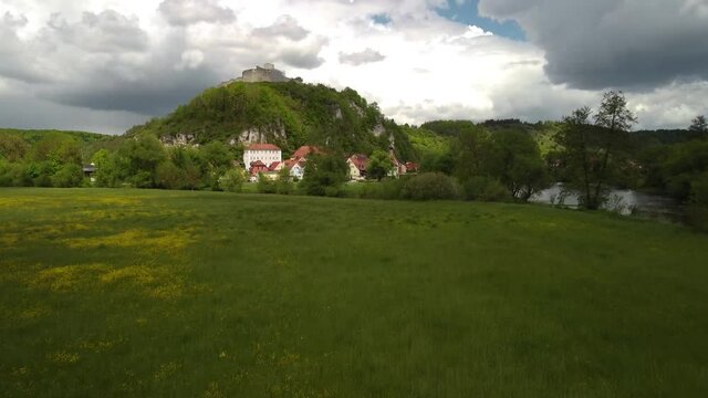 Drone rising up and flying towards Kallm&uuml;nz, Upper Palatinate, Bavaria on sunny day with dramatic clouds, establishing shot, reveal shot