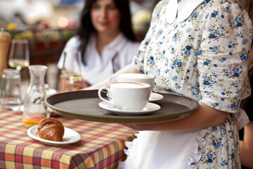 waitress holding tray with cups of coffee