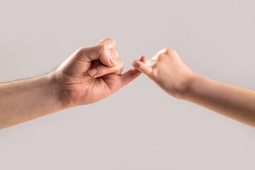 Little finger of the two hands hold together. Show friendship and forgiveness. Friendship of generations. Father, daughter hand making promise friendship concept. Child hook little finger together