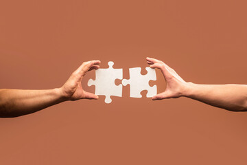 Holding puzzle. Business solutions, success and strategy concept. Two hands trying to connect...