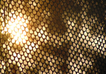 Close up of a metal Net fence with blurred sunset background, chain link fence background on the sunset. Sunset through a steel mesh net in a zoo