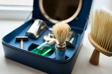 Barber shaving kit and brush lying in blue box with mirror. Concept of hygiene beauty and haircare. - obrazy, fototapety, plakaty