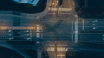 Aerial view of a junction with road markings at night.