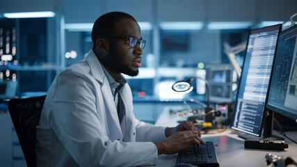 Modern Electronics Development Facility: Male Engineer Works on Computer with CAD Programming Software. Scientists Design of Industrial PCB, New Generation Silicon Microchips, Semiconductors