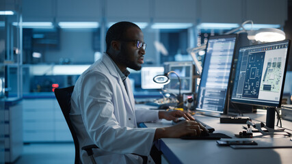 Modern Electronics Development Facility: Male Engineer Works on Computer with CAD Programming...