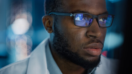Portrait of Handsome Black Man Wearing Glasses Working Confidently on a Computer. Young Intelligent...