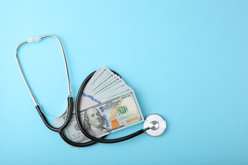 Medical stethoscope and money on a colored background top view close-up