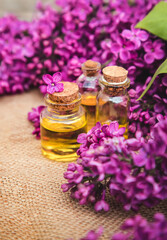 Obraz na płótnie Canvas Lilac essential oil in a small bottle. Selective focus.