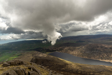 Photograph taken from the top of Slieve Binnian Mountain with the Ben Crom reservoir in the background, with storm clouds