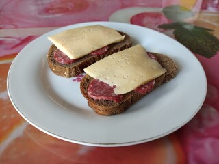 Two salami and cheese sandwiches on a plate