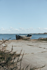 Fototapeta na wymiar Old forgotten rusty boat on Baltic seashore on Baltic spit