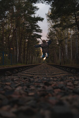 skaczące dziecko nad torami kolejowymi