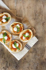 Homemade mini pizzas margarita with tomato, mozzarella and basil