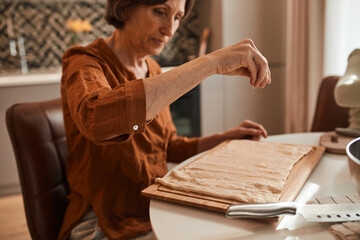 Fototapeta na wymiar Woman sprinkle sesame seeds on the dough while cooking and baking at the kitchen