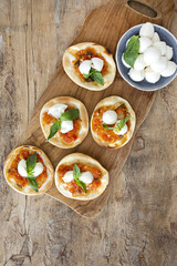 Homemade mini pizzas margarita with tomato, mozzarella and basil