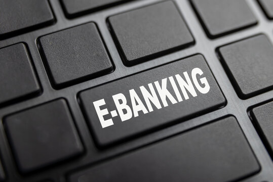Black pc keyboard, with yellow text "E-banking". Carrying out online banking transactions from a pc, smart phone, or tablet.