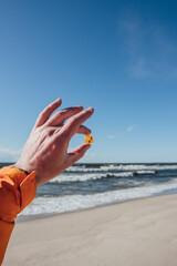 Male hand holds amber on sea background